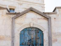 Blaue Holztür in kunstvollem Türrahmen in Ortahisar